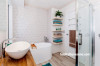 white bathroom, freestanding bath, geometric tiles, open shelving 